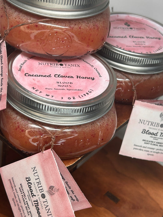 NutriBotanix Blood Moon Creamed Clover Honey in 7 oz glass jars with pink labels.